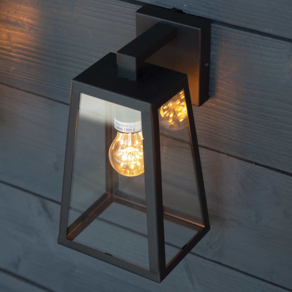 Lampe murale d'extérieur au design épuré, noir, boîtier noir avec verre clair, culot noir avec ampoule visible 